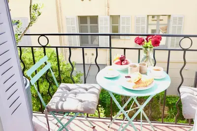 a table with a plate of food on a balcony at 70m2 Apartment - La Roseraie in Cannes