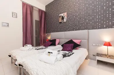 two beds in a room with purple and white sheets at Marylin 2 pièces 3 étoiles, plein coeur de Cannes, 5mn Palais et plages in Cannes