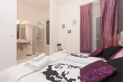 two beds in a room with purple and white at Marylin 2 pièces 3 étoiles, plein coeur de Cannes, 5mn Palais et plages in Cannes