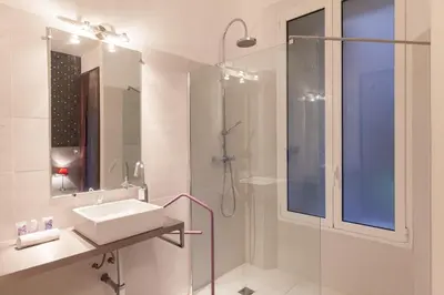 a white bathroom with a sink and a shower at Marylin 2 pièces 3 étoiles, plein coeur de Cannes, 5mn Palais et plages in Cannes