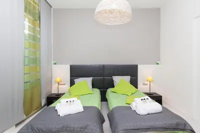 two beds in a bedroom with green and grey at ZEN 2 pièces 3 étoiles, plein centre cannes, à 5mn des plages et du palais in Cannes