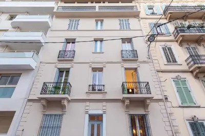 a tall white building with windows and balconies at ZEN 2 pièces 3 étoiles, plein centre cannes, à 5mn des plages et du palais in Cannes