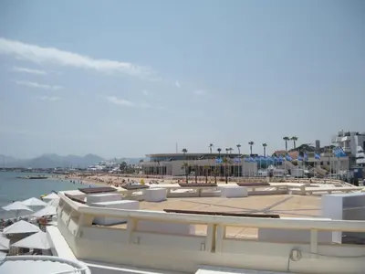 a beach with umbrellas and a group of boats at ZEN 2 pièces 3 étoiles, plein centre cannes, à 5mn des plages et du palais in Cannes