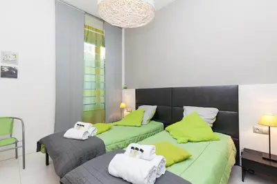 two beds in a room with green and gray at ZEN 2 pièces 3 étoiles, plein centre cannes, à 5mn des plages et du palais in Cannes
