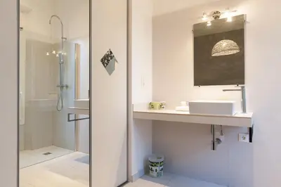 a white bathroom with a sink and a shower at ZEN 2 pièces 3 étoiles, plein centre cannes, à 5mn des plages et du palais in Cannes
