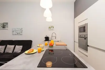 a kitchen with a table with a black counter top at ZEN 2 pièces 3 étoiles, plein centre cannes, à 5mn des plages et du palais in Cannes