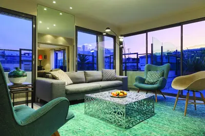 a living room with a couch and chairs and a table at Nehô Suites Cannes Croisette in Cannes
