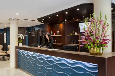 a large blue wall in a room with a suitcase at Nehô Suites Cannes Croisette in Cannes