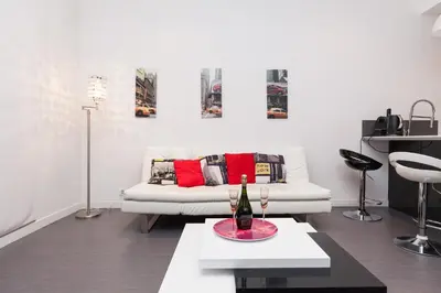 a living room with a white couch with red pillows at Manhattan 2 pièces 3 étoiles lumineux plein centre à 5mn des plages et palais in Cannes