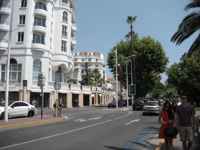 two people walking down a street in a city at Manhattan 2 pièces 3 étoiles lumineux plein centre à 5mn des plages et palais in Cannes