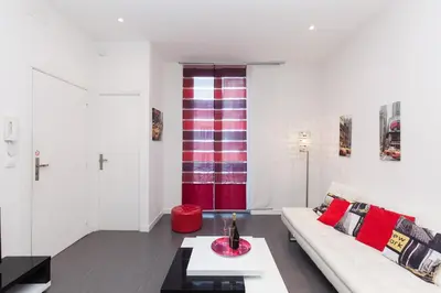 a living room with a white couch and red pillows at Manhattan 2 pièces 3 étoiles lumineux plein centre à 5mn des plages et palais in Cannes