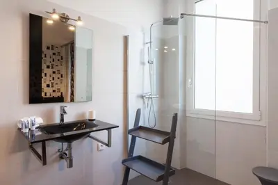 a bathroom with a sink and a glass shower at New York 2 pièces 3 étoiles calme plein centre de cannes, 5mn des plages et Palais in Cannes
