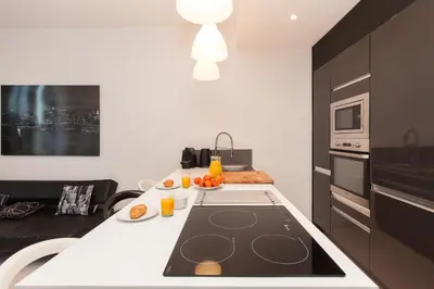 a kitchen with a black and white counter top at New York 2 pièces 3 étoiles calme plein centre de cannes, 5mn des plages et Palais in Cannes