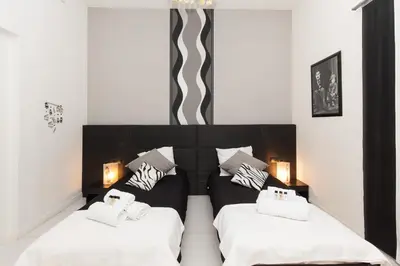 a bedroom with two beds with white sheets at Charlie Chaplin 2 pièces 3 étoiles calme plein centre de Cannes, 5mn des plages et Palais in Cannes