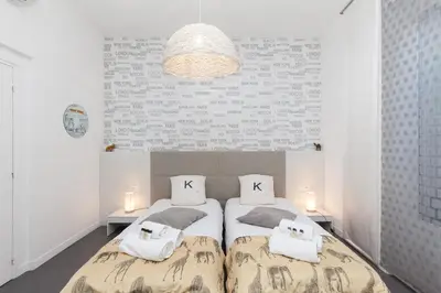 a bedroom with two beds and a large wall at Voyage 2 pièces 3 étoiles calme plein centre à 5mn des plages et du Palais in Cannes