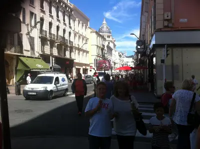 a group of people walking down a city street at 7e Art 2 pièces 3 étoiles calme plein centre Cannes 5mn plages et Palais in Cannes