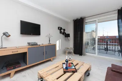 a living room with a tv and a coffee table at Loft 3 pièces duplex 3 étoiles calme centre ville à 5 mn des plages et palais in Cannes