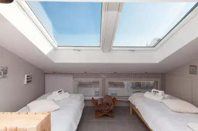 a room with three beds and a skylight at Loft 3 pièces duplex 3 étoiles calme centre ville à 5 mn des plages et palais in Cannes