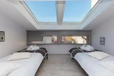 a row of beds in a room with a skylight at Loft 3 pièces duplex 3 étoiles calme centre ville à 5 mn des plages et palais in Cannes