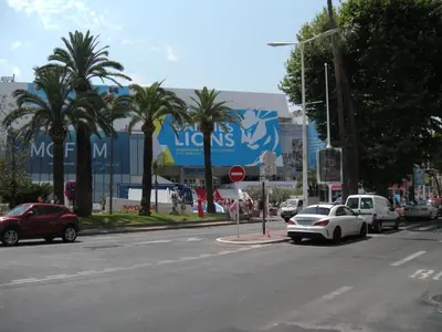 a city street with cars parked in front of a building at Cocooning 3 pièces duplex 3 étoiles calme centre ville à 5mn plages et Palais in Cannes