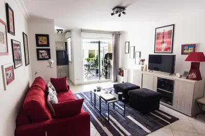 a living room with a red couch and two chairs at Le Parc Pointe Croisette in Cannes