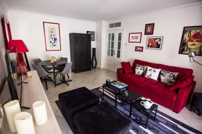 a living room with a red couch and a table at Le Parc Pointe Croisette in Cannes