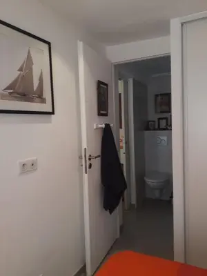 a bathroom with a door leading into a room with a toilet at Le Tivoli in Cannes