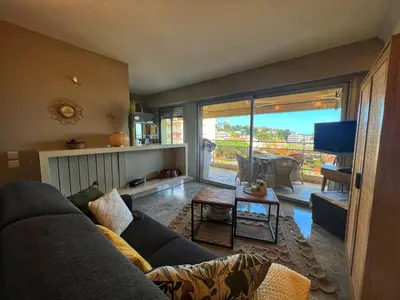 a living room with a couch and a tv at Les Roses by Welcome to Cannes in Cannes