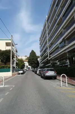 an empty street with cars parked next to a building at Les Roses by Welcome to Cannes in Cannes