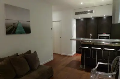 a living room with a couch and a kitchen at Appartements Urban et Pure in Cannes