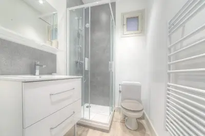 a white bathroom with a shower and a toilet at IMMOGROOM - Appartment - 1min from the beach - Wifi in Cannes