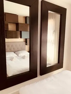 a mirror in front of a bed in a room at Cannes Pool & Beach in Cannes