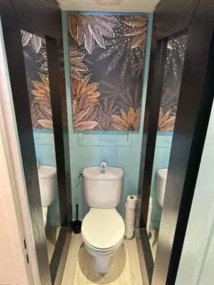 a bathroom with a toilet and a painting on the wall at Cannes Pool & Beach in Cannes