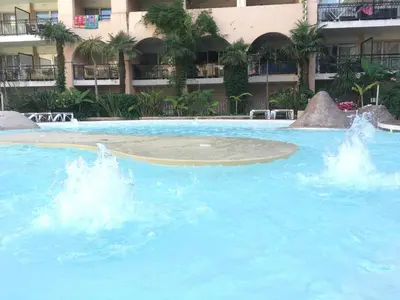 a large pool with blue water in front of a building at Cannes Pool & Beach in Cannes