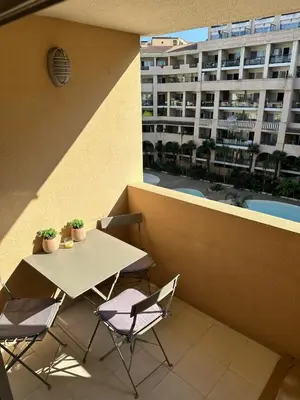 a table and chairs on a balcony with a building at Cannes Pool & Beach in Cannes