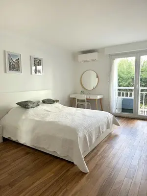 a white bedroom with a large bed and a mirror at Appartement rénové CANNES, palm beach in Cannes
