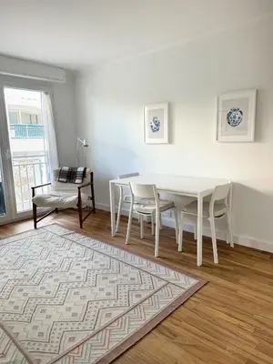 a white dining room with a white table and chairs at Appartement rénové CANNES, palm beach in Cannes