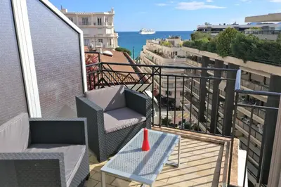 a balcony with two chairs and a table and the ocean at Nice apartment last floor with terrace and clear view on the sea in Cannes