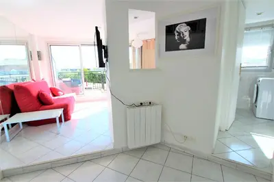 a living room with a red couch and a chair at Nice apartment last floor with terrace and clear view on the sea in Cannes