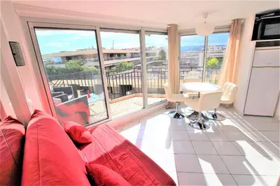 a living room with a couch and a table at Nice apartment last floor with terrace and clear view on the sea in Cannes