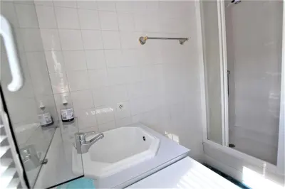 a white bathroom with a sink and a shower at Nice apartment last floor with terrace and clear view on the sea in Cannes