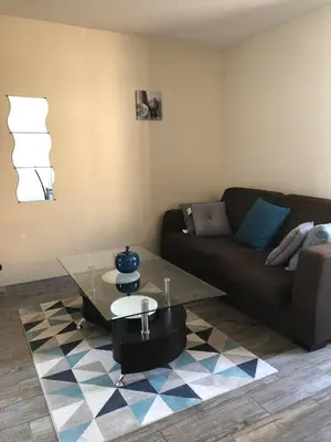 a living room with a couch and a coffee table at Vacances Cannoise, mer et piscine in Cannes