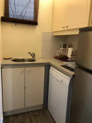 a small kitchen with a sink and a refrigerator at Vacances Cannoise, mer et piscine in Cannes