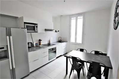 a kitchen with a table and chairs and a refrigerator at RUE D'ANTIBES CENTER in Cannes