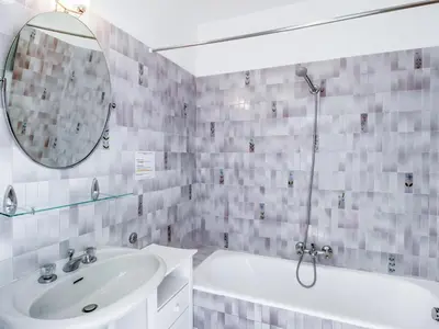 a bathroom with a sink and a tub and a mirror at Apartment Les Hortensias by Interhome in Cannes