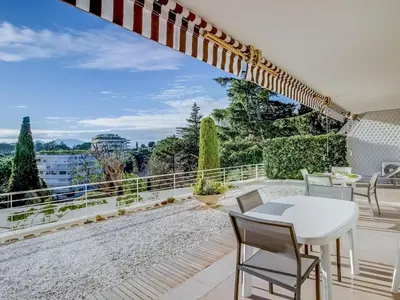 a patio with a white table and chairs on a balcony at Apartment Les Hortensias by Interhome in Cannes