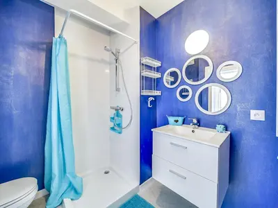 a blue bathroom with a toilet and a sink at Studio le Tivoli by Interhome in Cannes