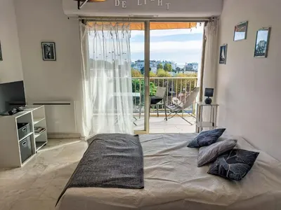a bedroom with a bed with a view of a balcony at Studio le Tivoli by Interhome in Cannes