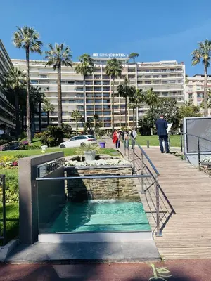 a bridge over a pool of water in a park at Agence des Résidences - Appartements privés du 45 CROISETTE - Standard in Cannes