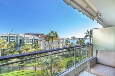 a balcony with a couch and a view of the ocean at Agence des Résidences - Appartements privés du 45 CROISETTE - Standard in Cannes